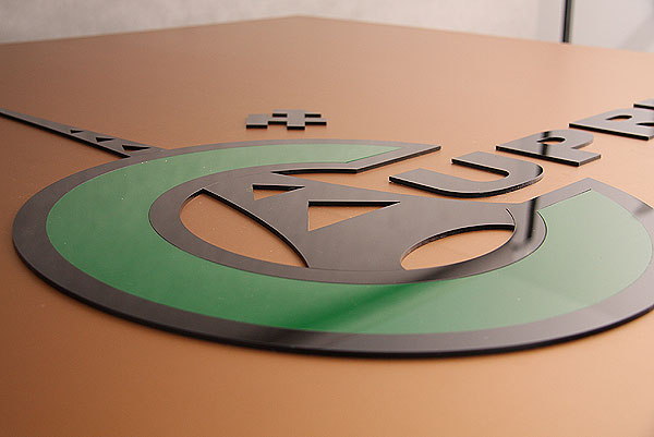 Wypukłe logo Cuprum z zielonej i czarnej pleksi