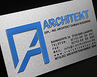 Srebrny, aluminiowy szyld reklamowy, z niebieskimi literami wypukłymi podświetlany diodami