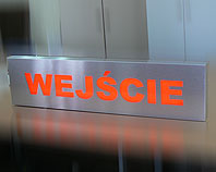 Wejście -srebrna podświetlana diodami tablica informacyjna nad wejściem do budynku 100 x 30 cm